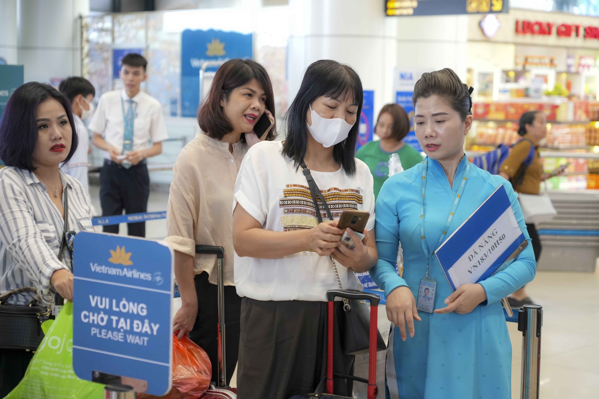 Nhân viên sân bay Nội Bài hỗ trợ hành khách sử dụng VNeID. 